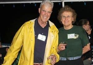 Two people smiling and standing together outdoors